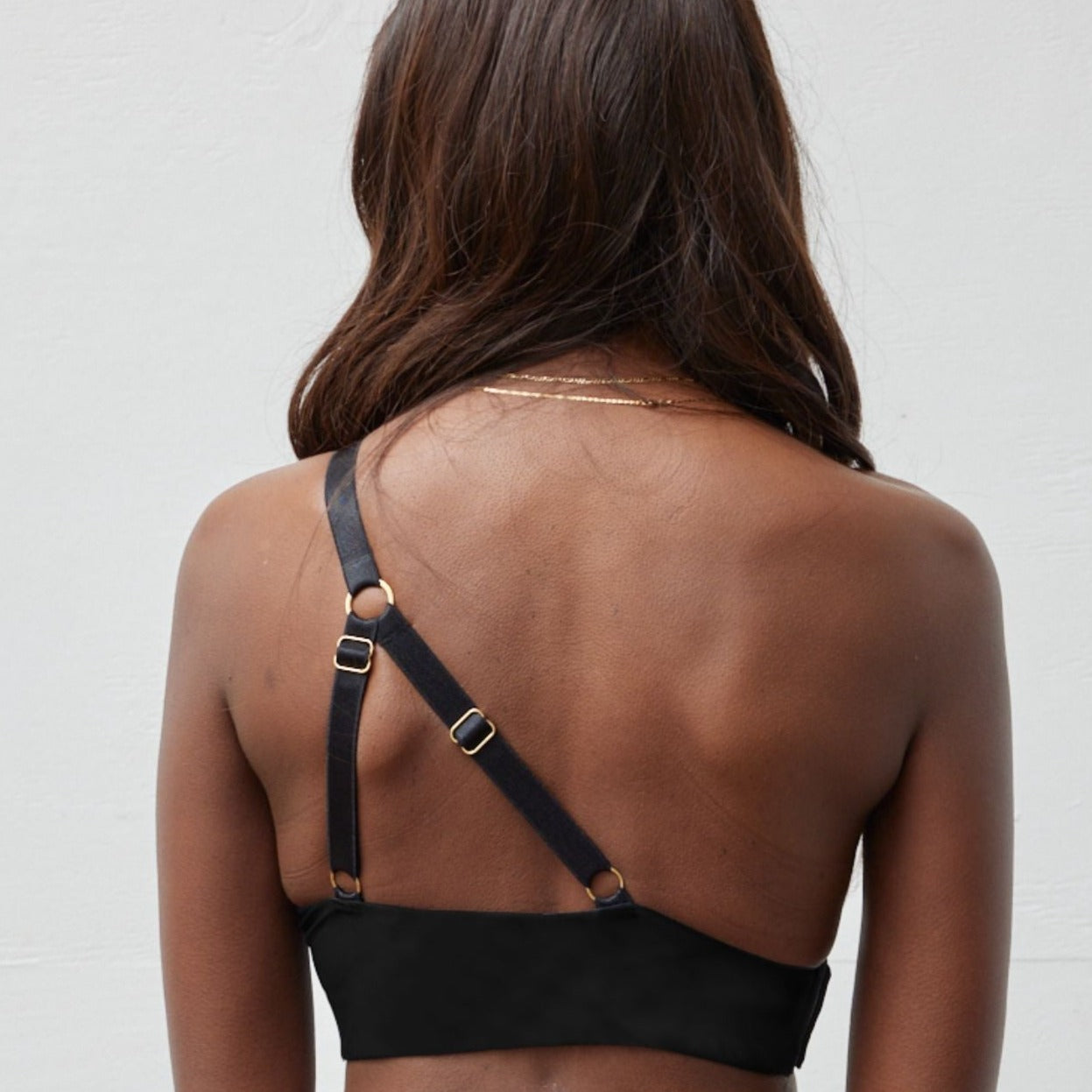 Rachel Left Unilateral Moulded Cup Sling Bra in Black | A moulded cup bra with a side closure and intricate strap design on the back, providing stability and contours your curves for a snug and secure fit.