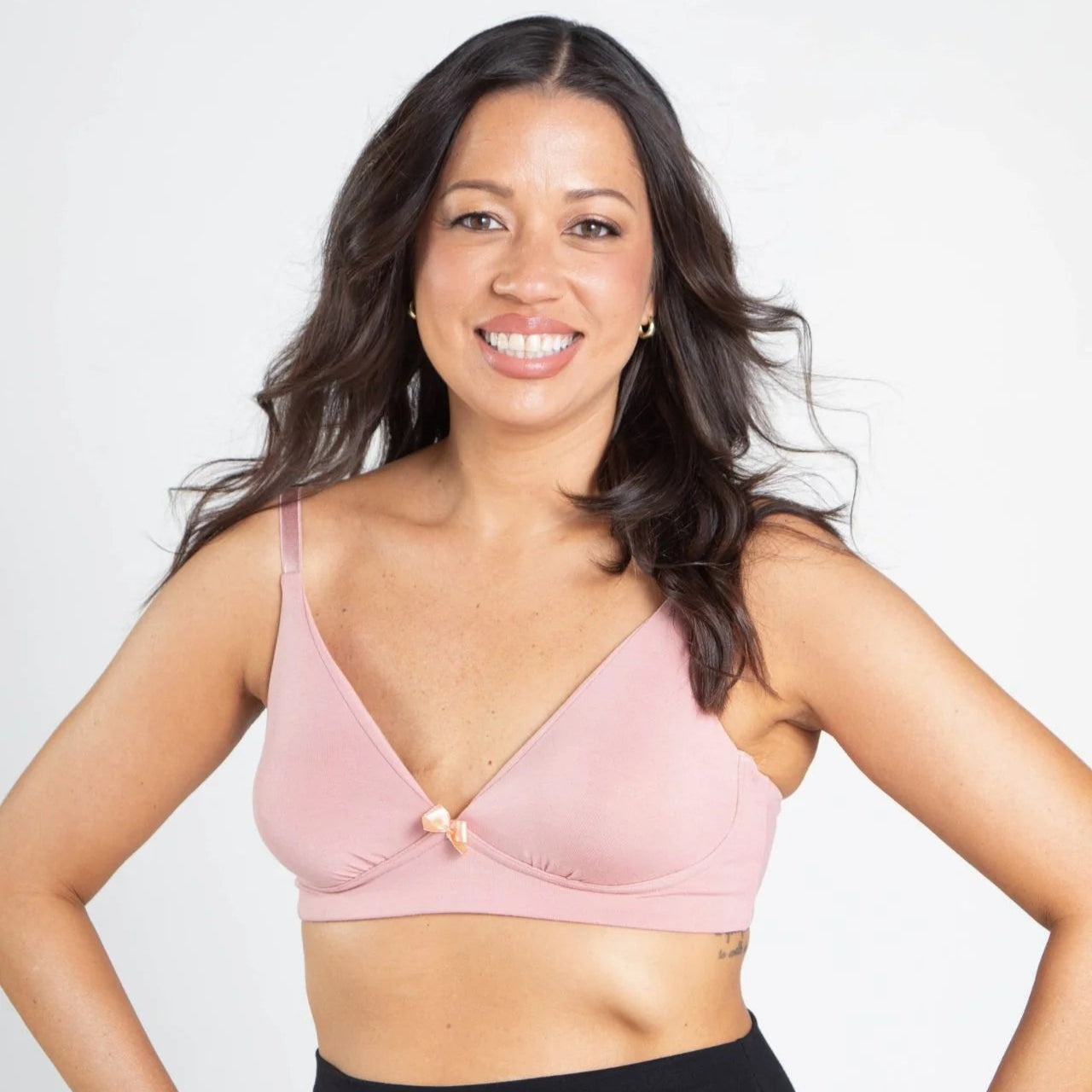 Woman wearing a pink bralette against a white background | Molly Pocketed Plunge Bra in Blush |  AnaOno | Post-surgery bras made just for those affected by breast cancer and breast surgery.